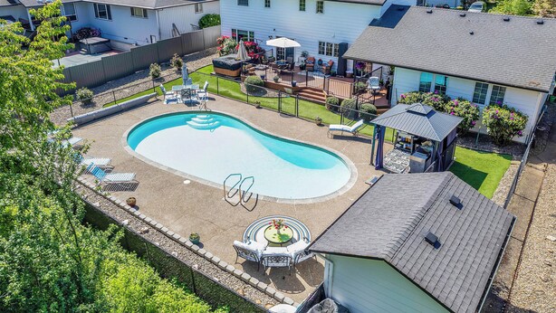 Un barrio residencial con piscina, mobiliario de patio y una zona de estar cubierta al aire libre.