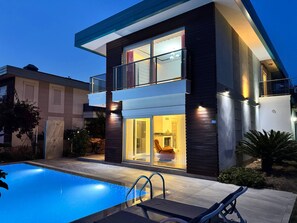 A modern two-story house with a swimming pool, a balcony, and a well-lit interior. - Entire villa in Keşefli, Turkey (Keşefli)
