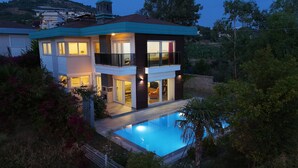 A two-story house with a swimming pool, large windows, and a balcony. - Entire villa in Keşefli, Turkey (Keşefli)