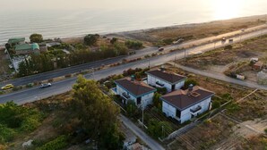 An aerial view of a coastal area with two modern houses, a road, and a beach. - Entire villa in Keşefli, Turkey (Keşefli)