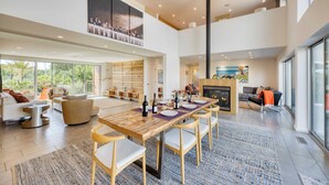 A spacious living area with a large wooden dining table, comfortable seating, and a fireplace.
