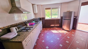 Apartamento família, sacada, vista para o jardim | Cozinha privada | Fogão, cooktop, talheres/pratos/utensílios de cozinha
