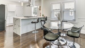 A modern kitchen with a central island, bar stools, and a dining table with chairs. - Modern & Fully Updated! ATL Home 4 Mi to Dtwn Fun (Atlanta)