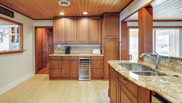 A kitchen with wooden cabinets, a built-in oven, and a granite countertop. - < 1 Mi to Boardwalk! Family Getaway in Ocean City (Ocean City)