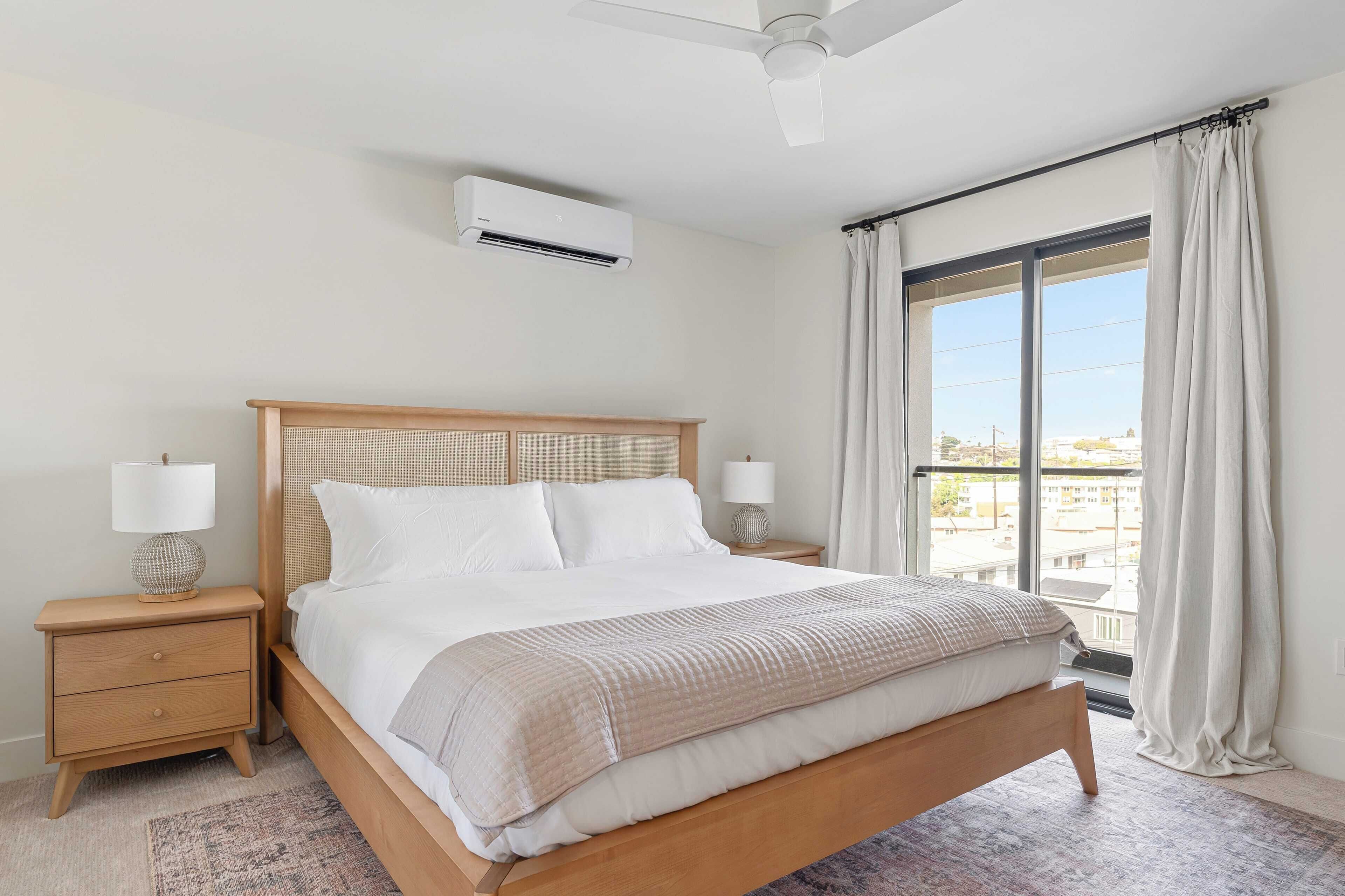A neatly made bed with a wooden headboard, a bedside lamp, and a nightstand.