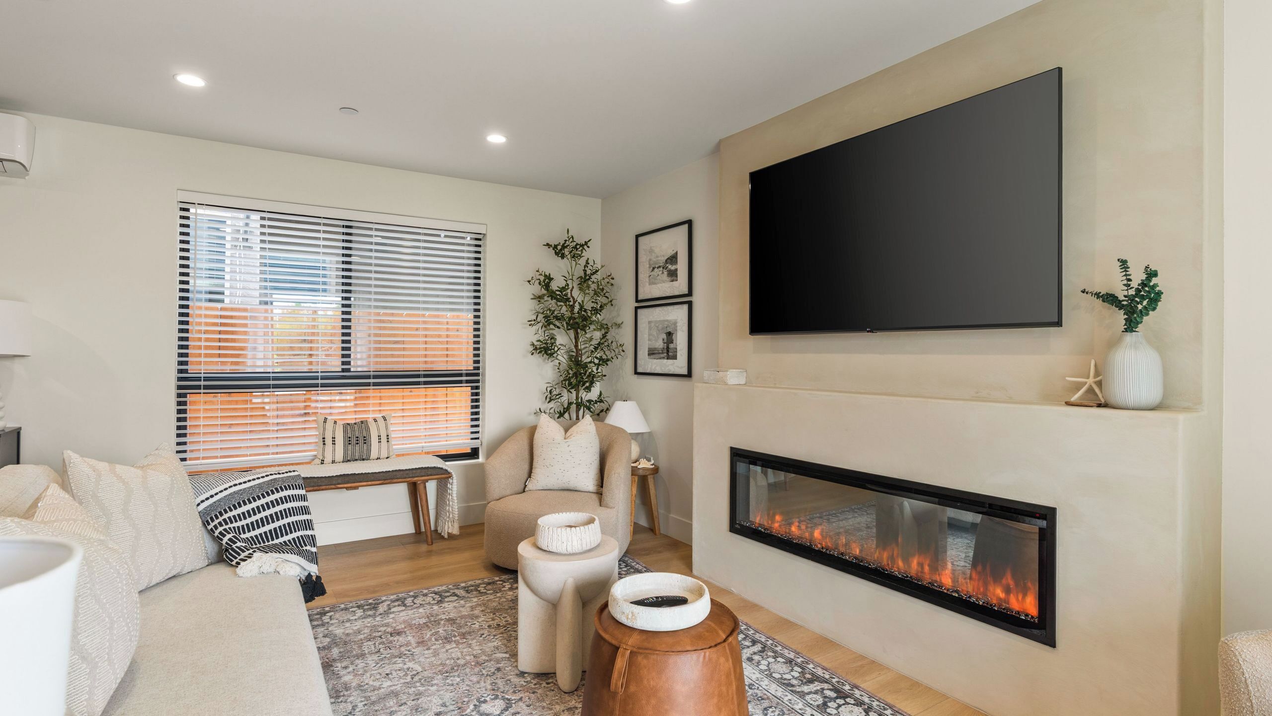 A modern living room with a fireplace, a flat-screen TV, and a comfortable seating area.