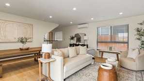 A living room with a sofa, a coffee table, a bench, and a rug.