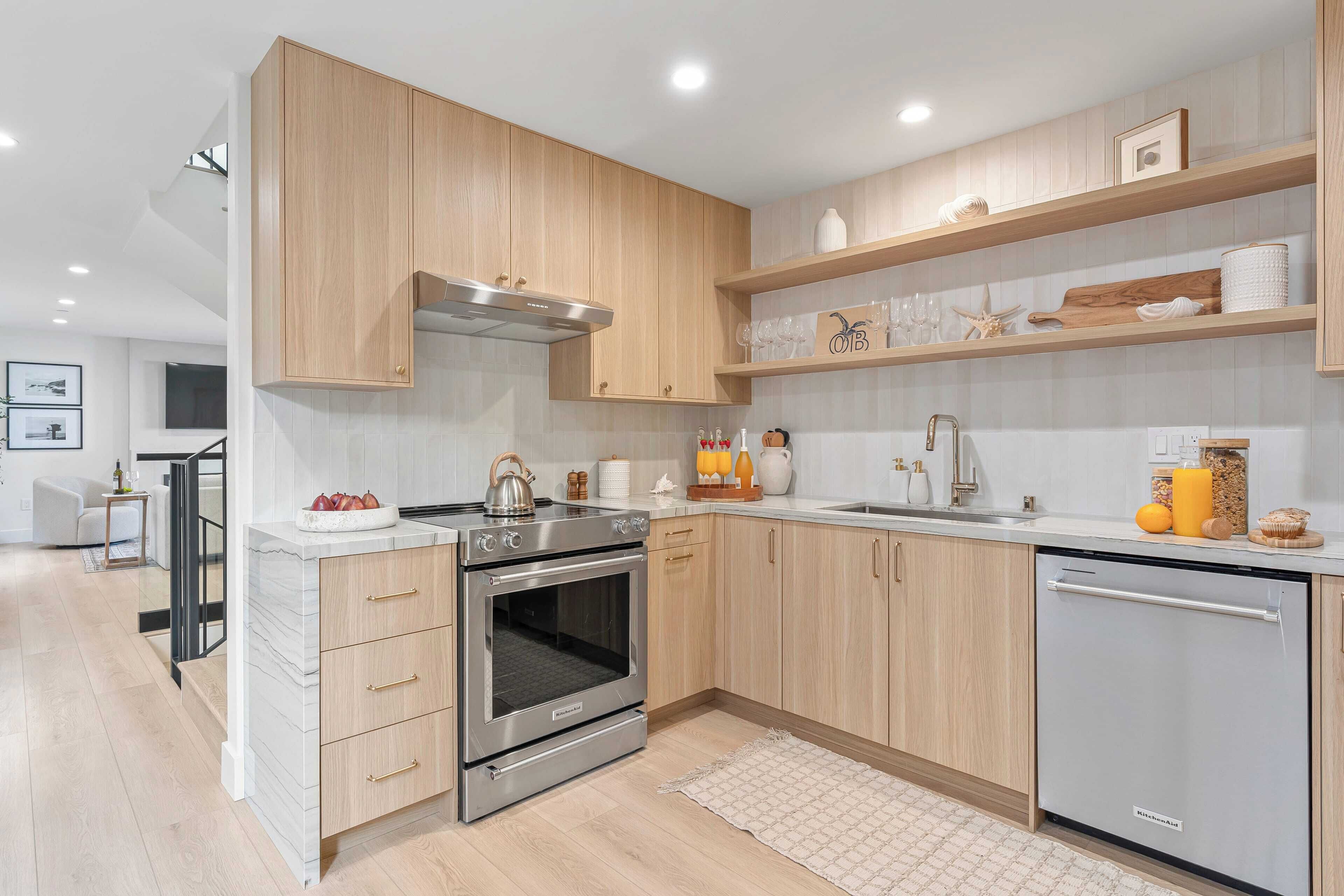 A modern kitchen with wooden cabinets, stainless steel appliances, and a white countertop.