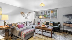A living room with a sofa, coffee table, and a television. - 2mins to Historic Main Street + Deer Valley Ski Lift Alpine Ember by Avantstay (Park City)