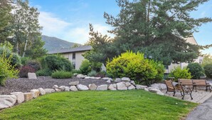 A landscaped garden with a lawn, a stone border, and benches. - 2mins to Historic Main Street + Deer Valley Ski Lift Alpine Ember by Avantstay (Park City)