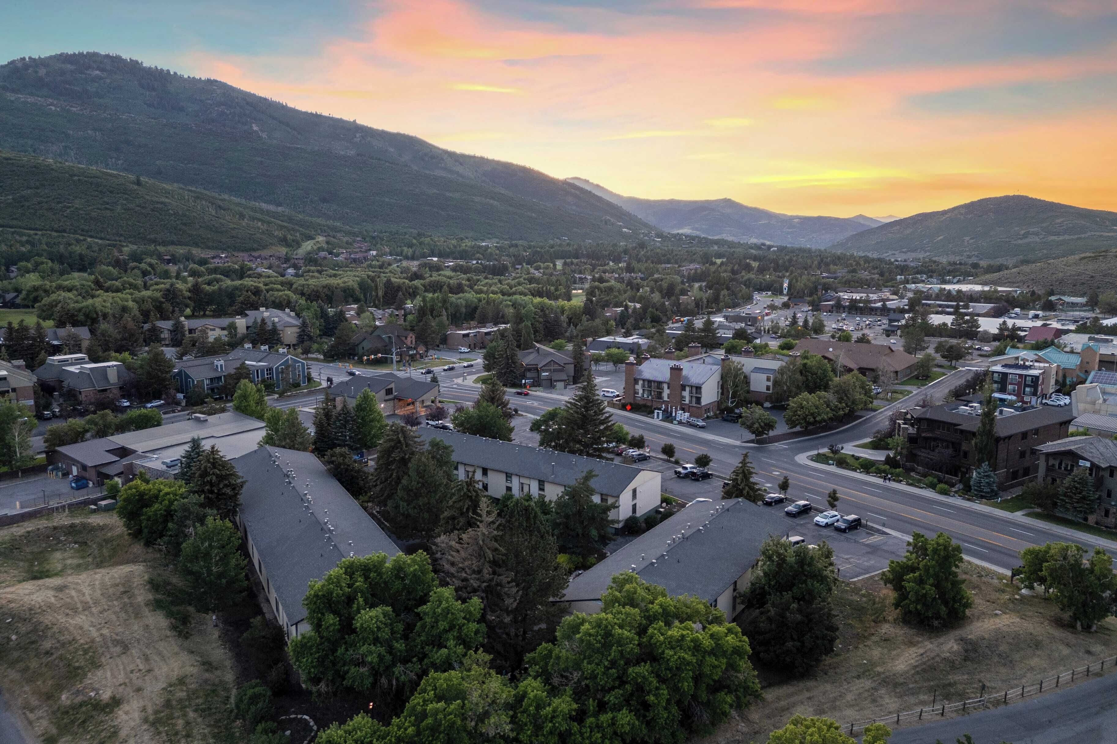A town with residential buildings, roads, and a mountainous backdrop.