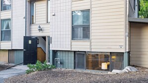 A multi-story building with a black door, a small porch, and a window with blinds. - 2mins to Historic Main Street + Deer Valley Ski Lift Alpine Ember by Avantstay (Park City)