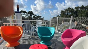 Outdoor seating with colorful chairs and a white fence. - La Calypso de Paimpol (Paimpol)