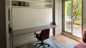 Un espace de bureau moderne comprenant un bureau, une chaise et un ventilateur de plafond.