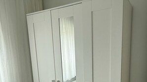 A white wardrobe with two doors and a mirror.