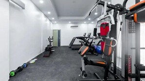 Ein Fitnessstudio mit Trainingsgeräten, Laufbändern und Gewichten.