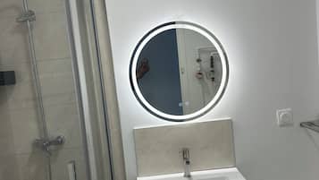 Een douche, handdoeken, zeep, toiletpapier