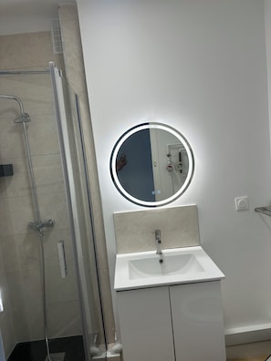 Een douche, handdoeken, zeep, toiletpapier