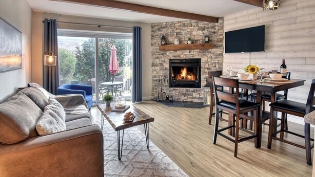 A living room with a fireplace, a dining area, and a sofa.