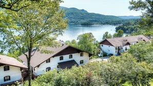 A lakeside village with traditional white houses, a clear view of the lake, and surrounding hills.