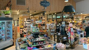 Een goed verlichte kruidenwinkel met houten wanden en diverse producten op planken.