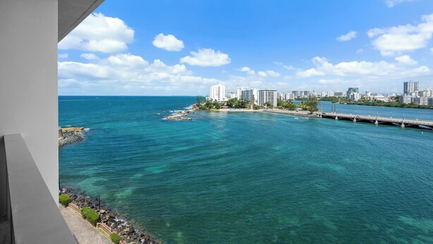 Un paysage urbain côtier offrant une vue dégagée sur l’océan et un pont reliant deux portions de terre.