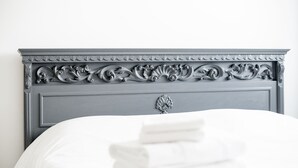 A bed with a grey headboard and neatly folded white towels. - Thomas House on Train Tracks (Venezia)