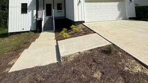 A single-story house with a garage, a small porch, and a concrete driveway.