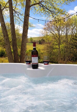 Un bain à remous avec une bouteille de vin et deux verres.