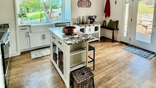 Una cocina con vigas de madera en el techo, un ventanal grande y un letrero que dice 'Corner Coffee Shop'.