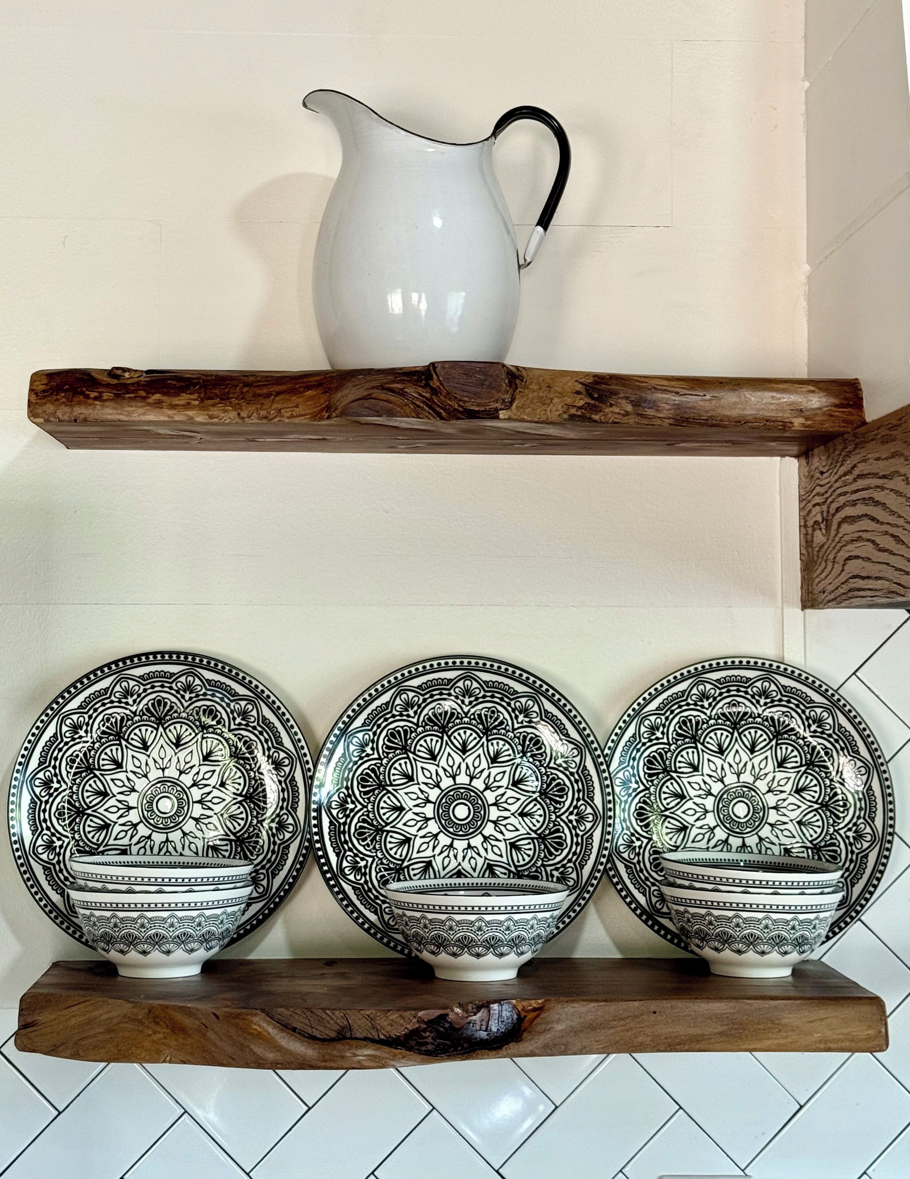 Una repisa de cocina con una jarra blanca y tres cuencos estampados.