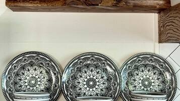 Una repisa de cocina con una jarra blanca y tres cuencos estampados.