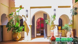 A courtyard with arches, potted plants, and a tiled floor. - Riad Dar Lalla (Marrakech)