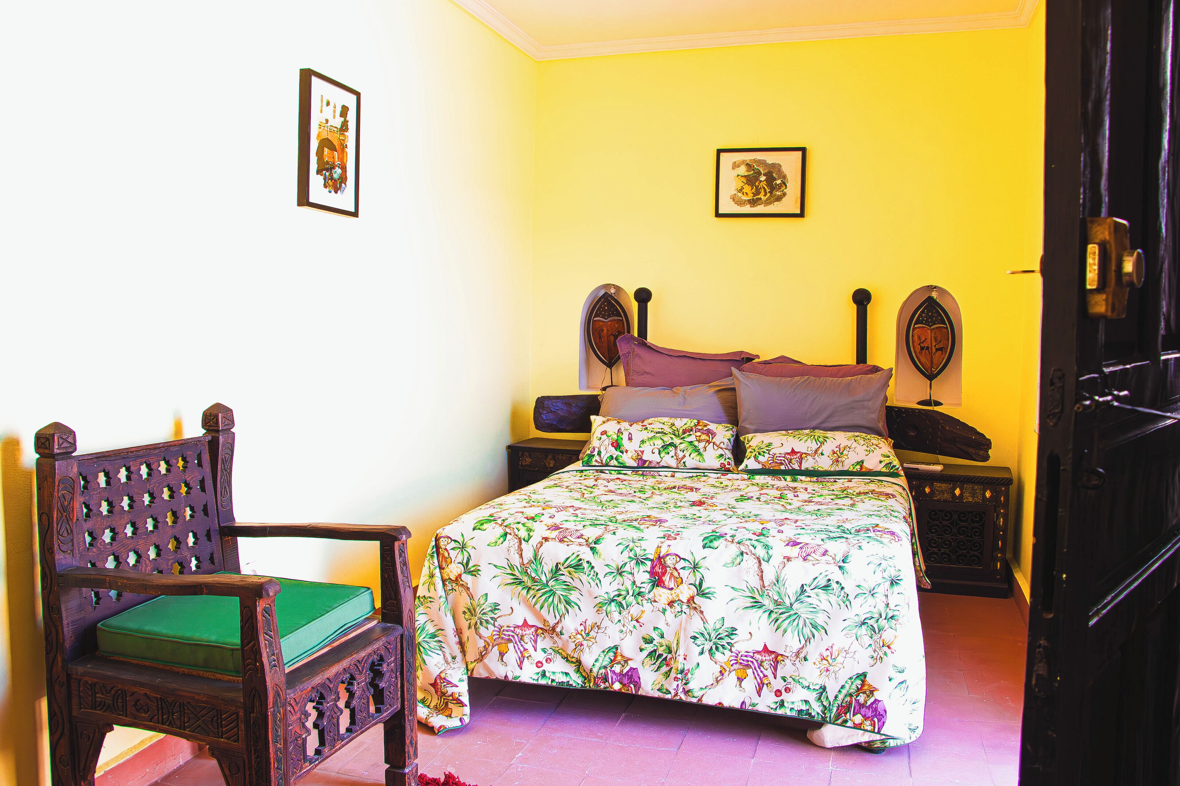 A room with a bed, a chair, and a door.