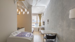 A narrow room with a bathtub, a small table, and a chair. - Cozy Studio in Asa Norte BSB Esz0103 (Brasília)