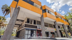 A multi-story building with a modern design, featuring large windows and a mix of brick and glass facades. - Cozy Studio in Asa Norte BSB Esz0103 (Brasília)