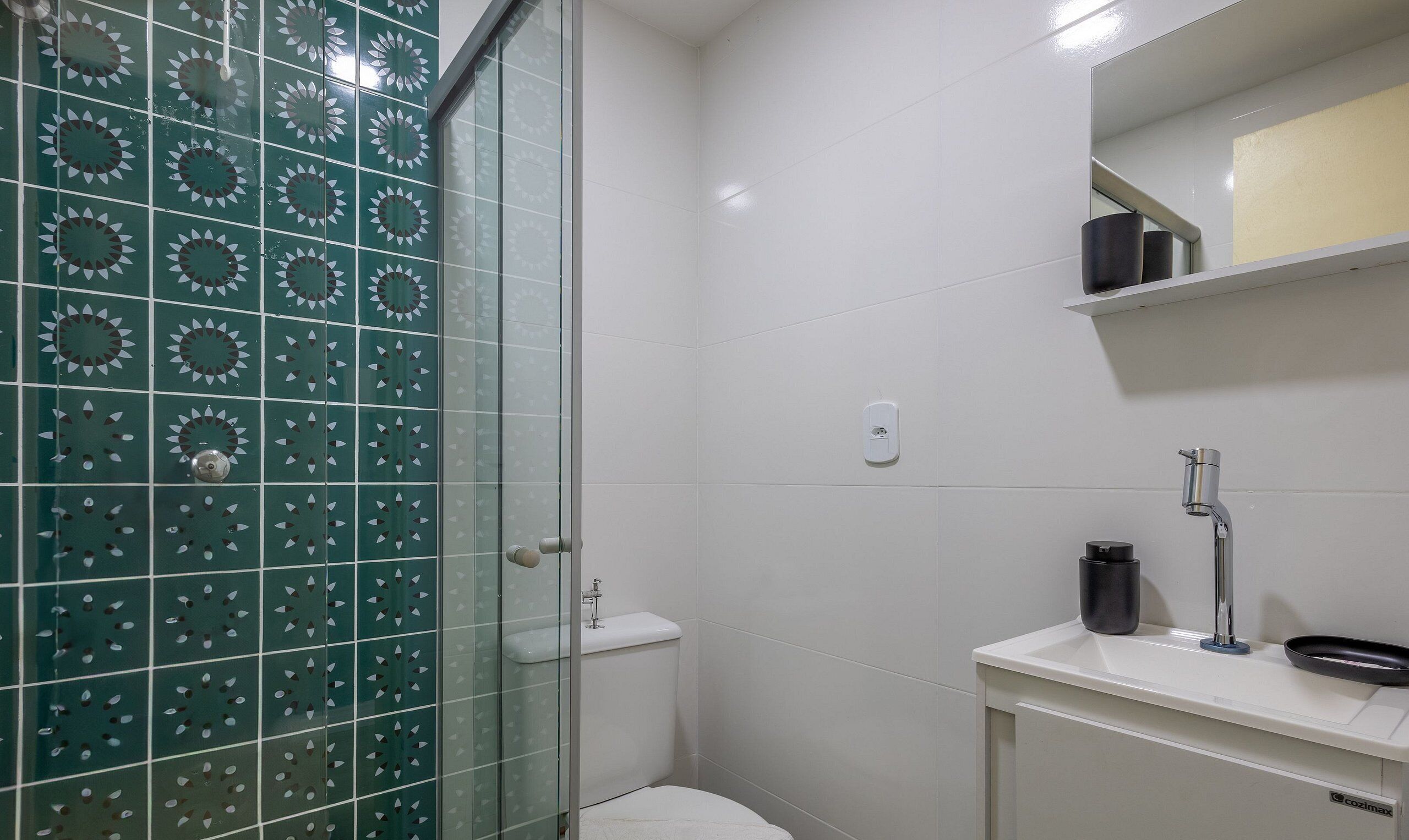 Un bagno con doccia, WC e lavandino.