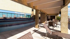 A rooftop pool area with lounge chairs and a view of the ocean. - Grand Mercure Brasilia 5 Estrelas - Gmb0414 (Brasília)