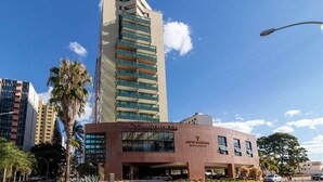 A modern hotel with a prominent tower and a lower building with a sign reading "Grand Mercury." - Grand Mercure Brasilia 5 Estrelas - Gmb0414 (Brasília)