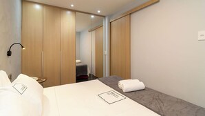 A hotel room with a bed, bedside table, lamp, and a mirror. - Grand Mercure Brasilia 5 Estrelas - Gmb0414 (Brasília)
