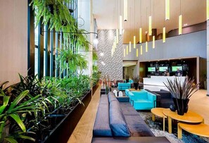 A modern lobby with a long bench, seating area, and a reception desk.