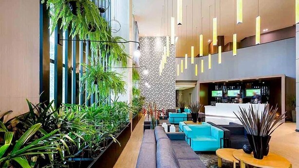 A modern lobby with a long bench, seating area, and a reception desk. - Grand Mercure Brasilia 5 Estrelas - Gmb0414 (Brasília)