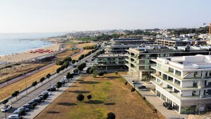 Un hôtel moderne à plusieurs étages, doté d’un parking et offrant une vue sur la plage.