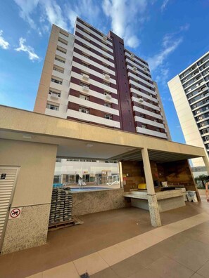 A modern building with a pool area, including a covered seating area and a poolside bar. - Beautiful Studios in Condominium With Pool - Aguas Claras - Madb (Águas Claras)