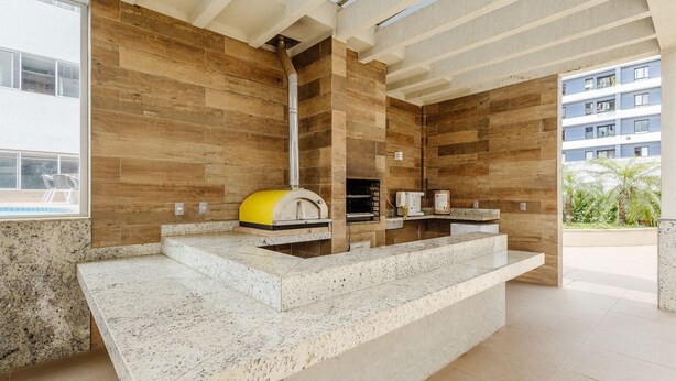 A modern kitchen with a built-in oven, granite countertops, and a view of the outside. - Beautiful Studios in Condominium With Pool - Aguas Claras - Madb (Águas Claras)