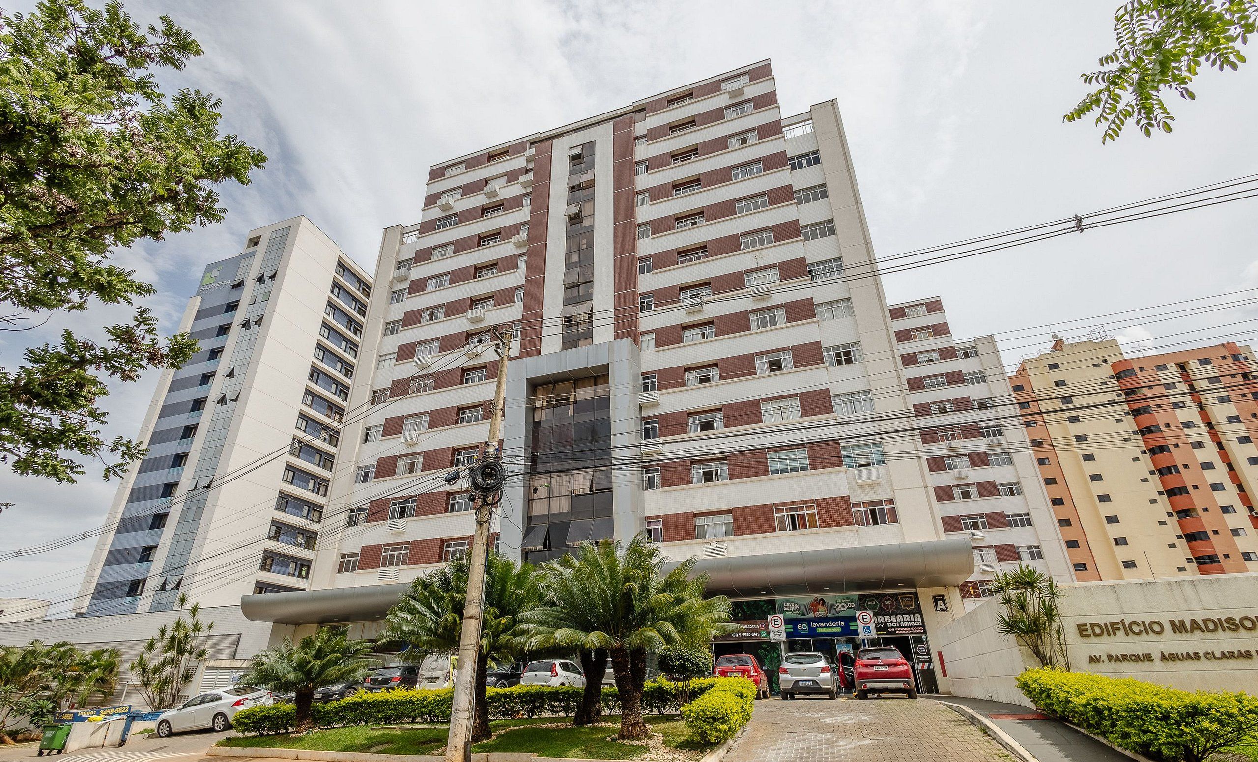 Edifício residencial de vários andares com design arquitetônico moderno, com varandas e uma entrada central.