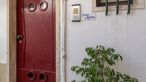 A red door with a number 34, a potted plant, and a sign reading "Casa Maria" on the wall.