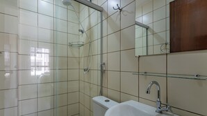 Ein Badezimmer mit Dusche, Toilette, Waschbecken und Spiegel.