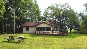 A house with a porch, a picnic table, and a yard. - White Potato Lake Cabin Retreat (Pound)