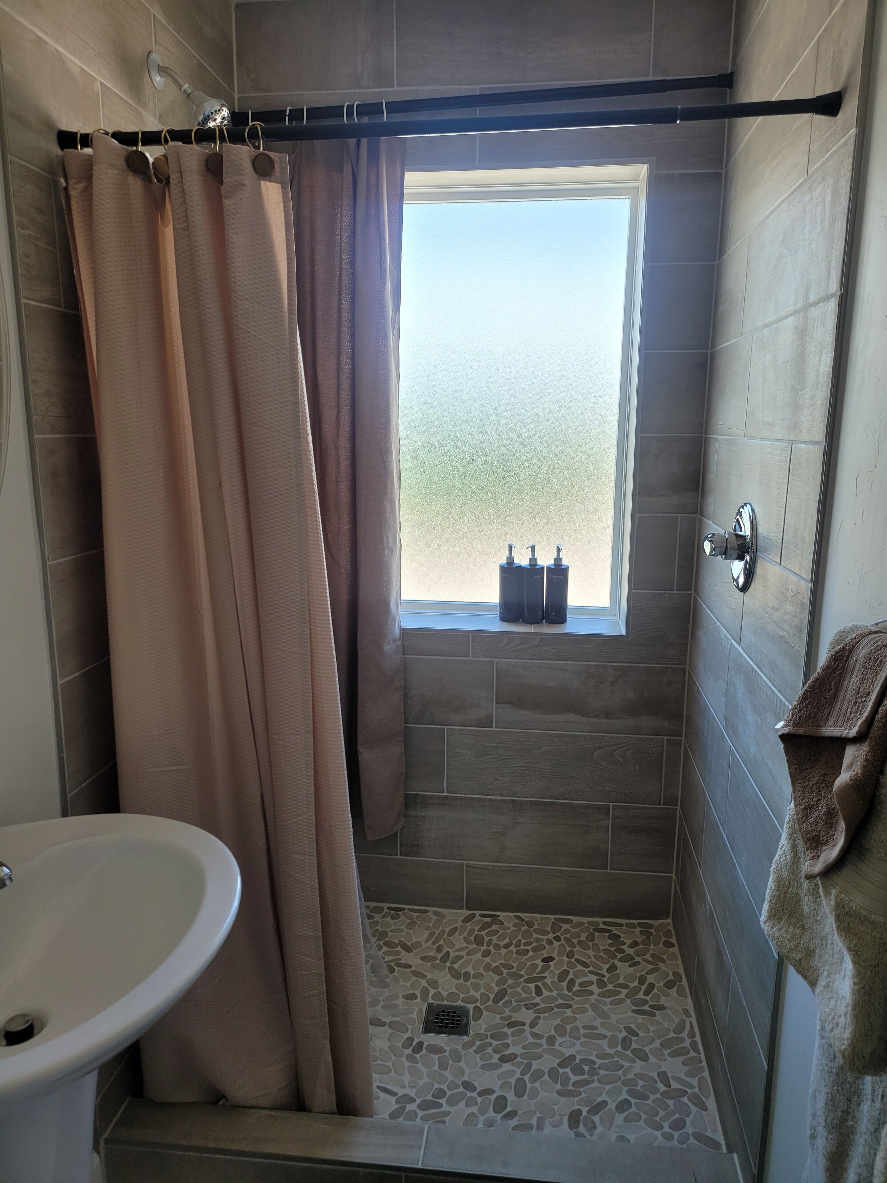 Een douche, handdoeken, zeep, toiletpapier
